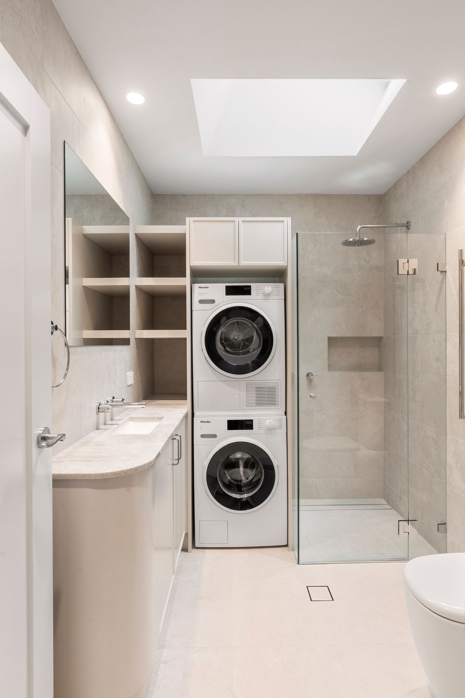 Modern Laundry Room With Stacked Washer and Dryer, Shower, and Vanity in Neutral Tones — ATH Projects in Mosman, NSW