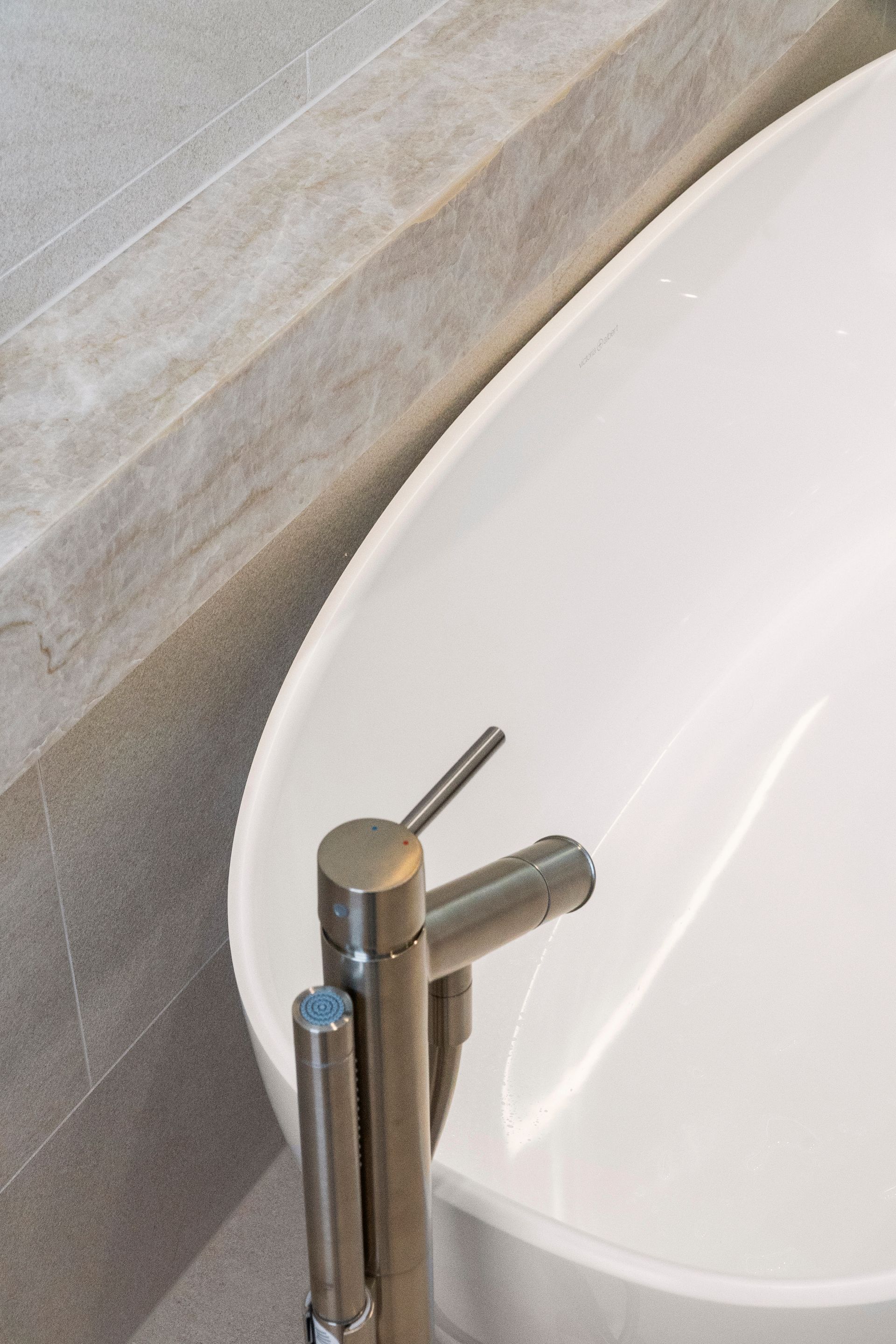 Brushed Nickel Faucet Next to a White Oval Bathtub — ATH Projects in Concord, NSW