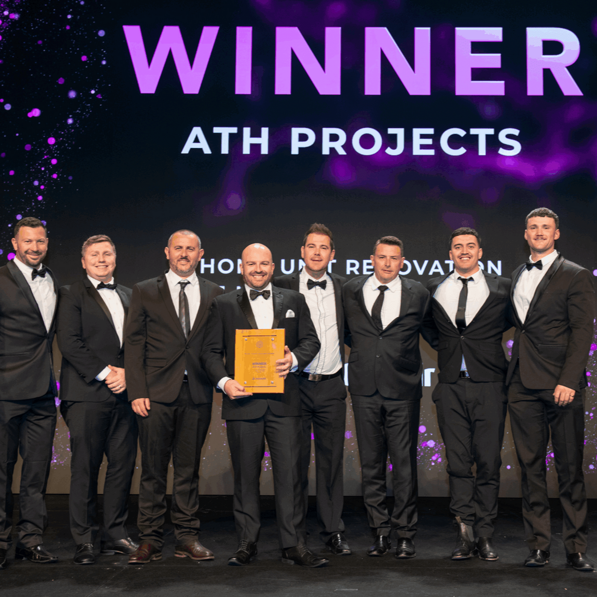 Group of Men in Tuxedos on Stage, Holding an Award — ATH Projects in Kirrawee, NSW