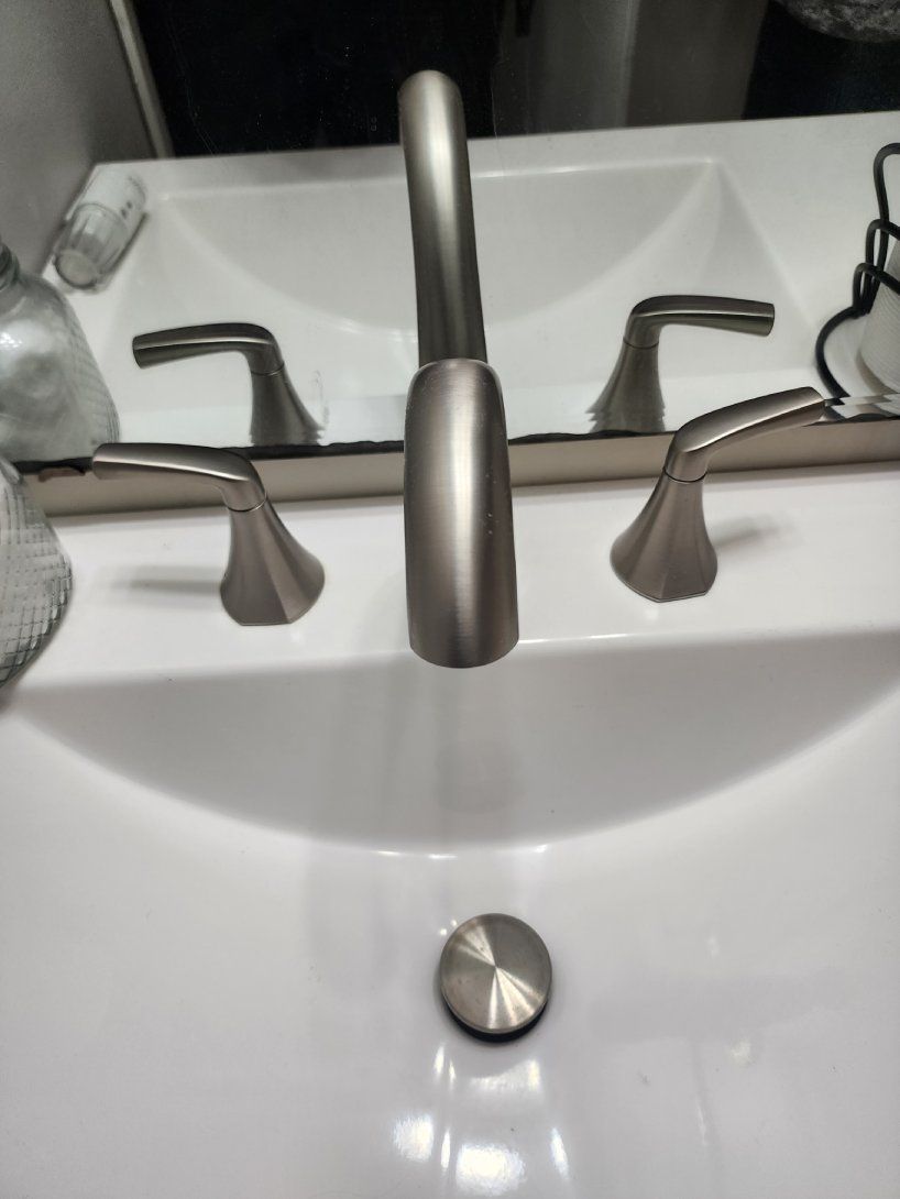 A faucet is covered in snow and ice and water is coming out of it.