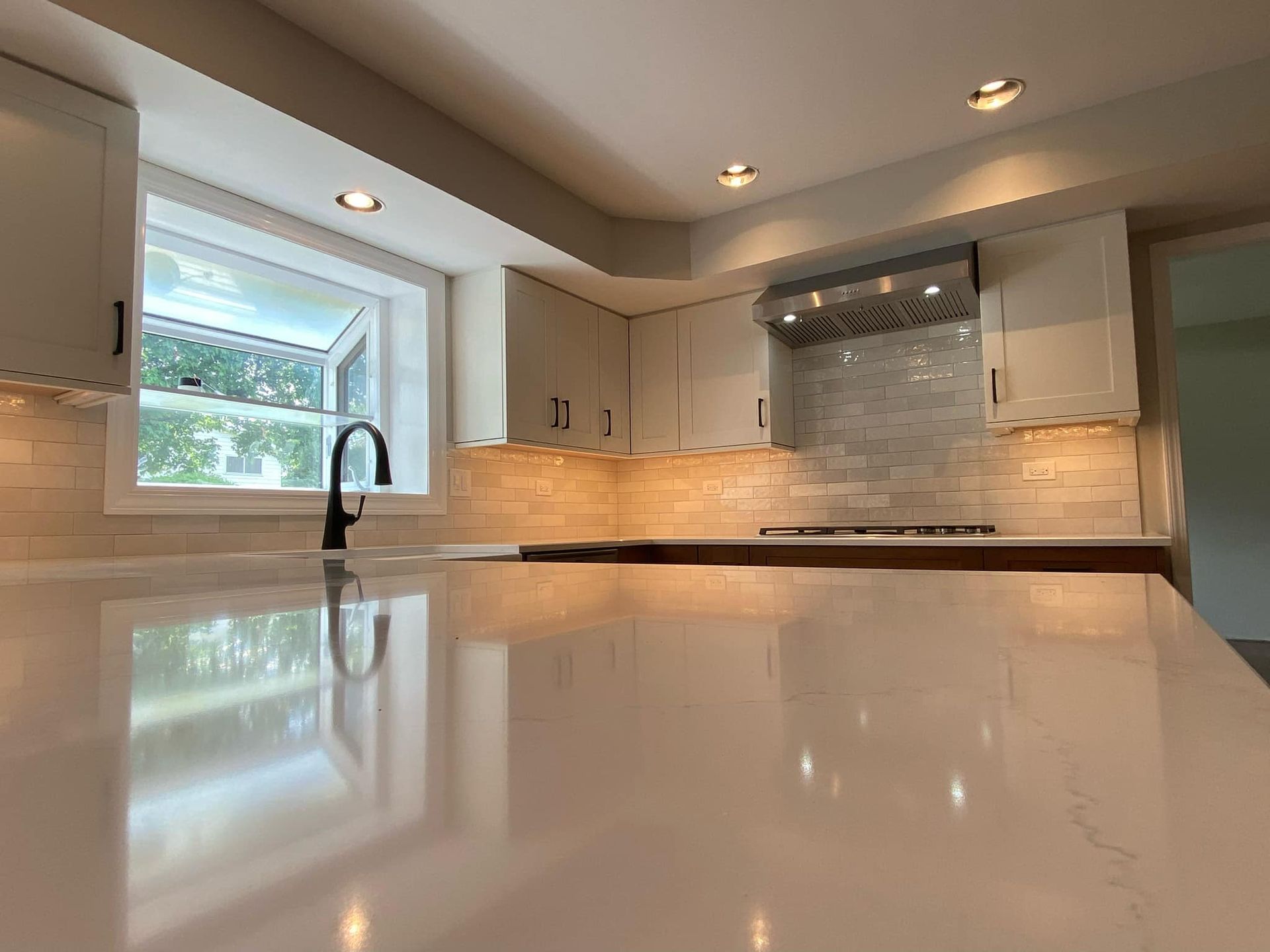 A & R Home Services kitchen with white cabinets , a sink , and a window.