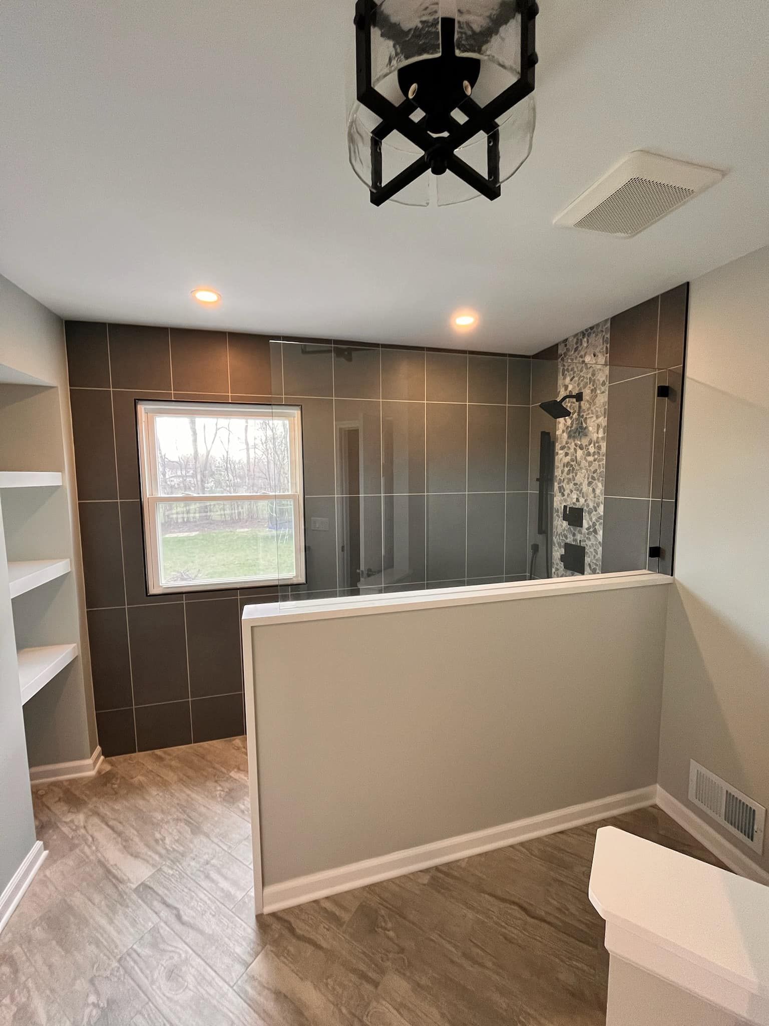 A & R Home Services remodel bathroom with a walk in shower and a window.