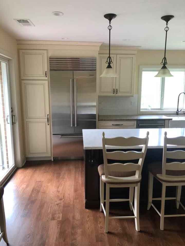 A & R Home Services kitchen with white cabinets and a stainless steel refrigerator