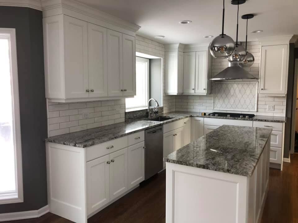 A & R Home Services  kitchen with white cabinets and granite counter tops.