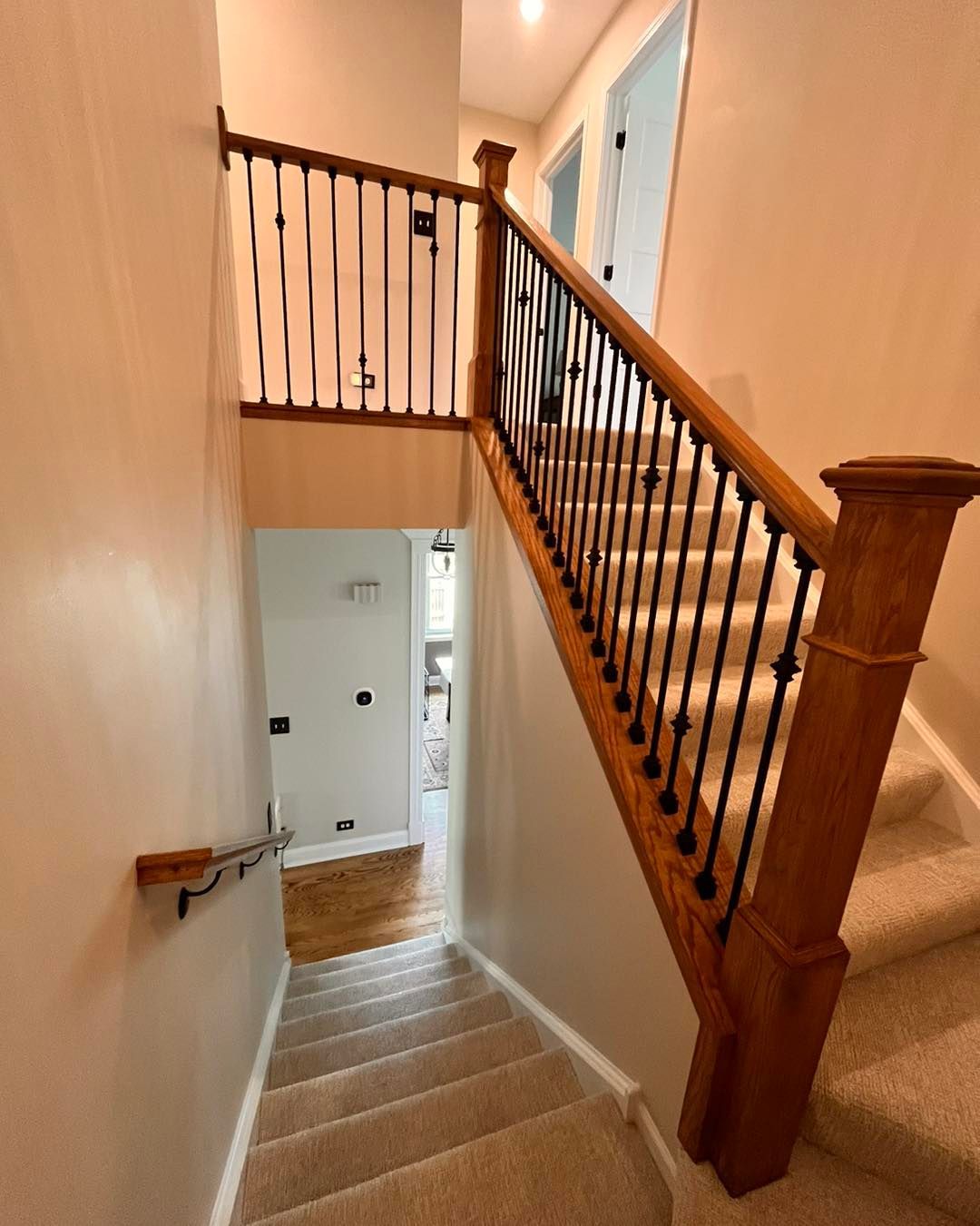 A & R Home Services remodel staircase with a wooden railing and carpeted steps leading up to the second floor 