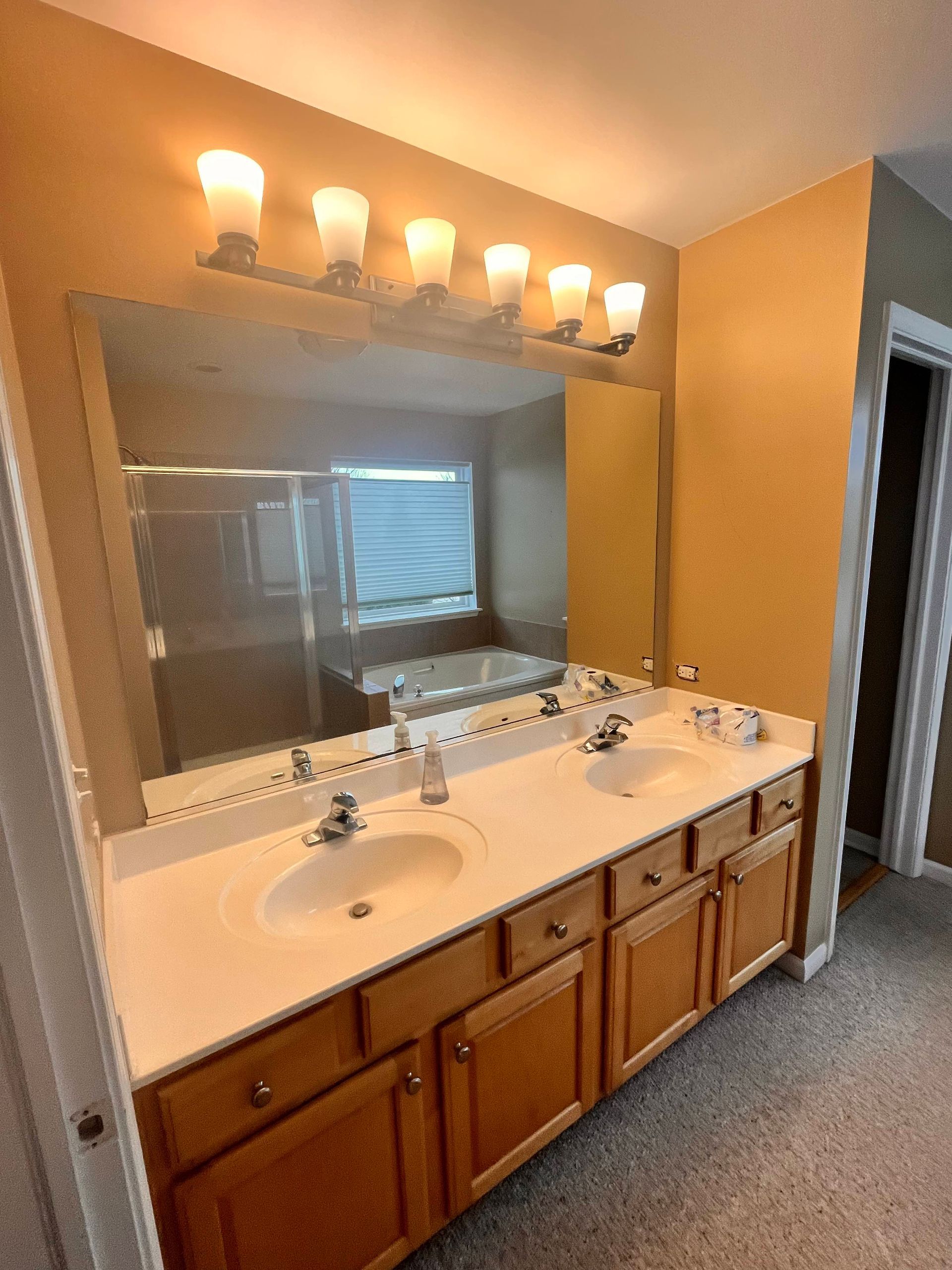 A & R Home Services remodel  bathroom with two sinks and a large mirror.