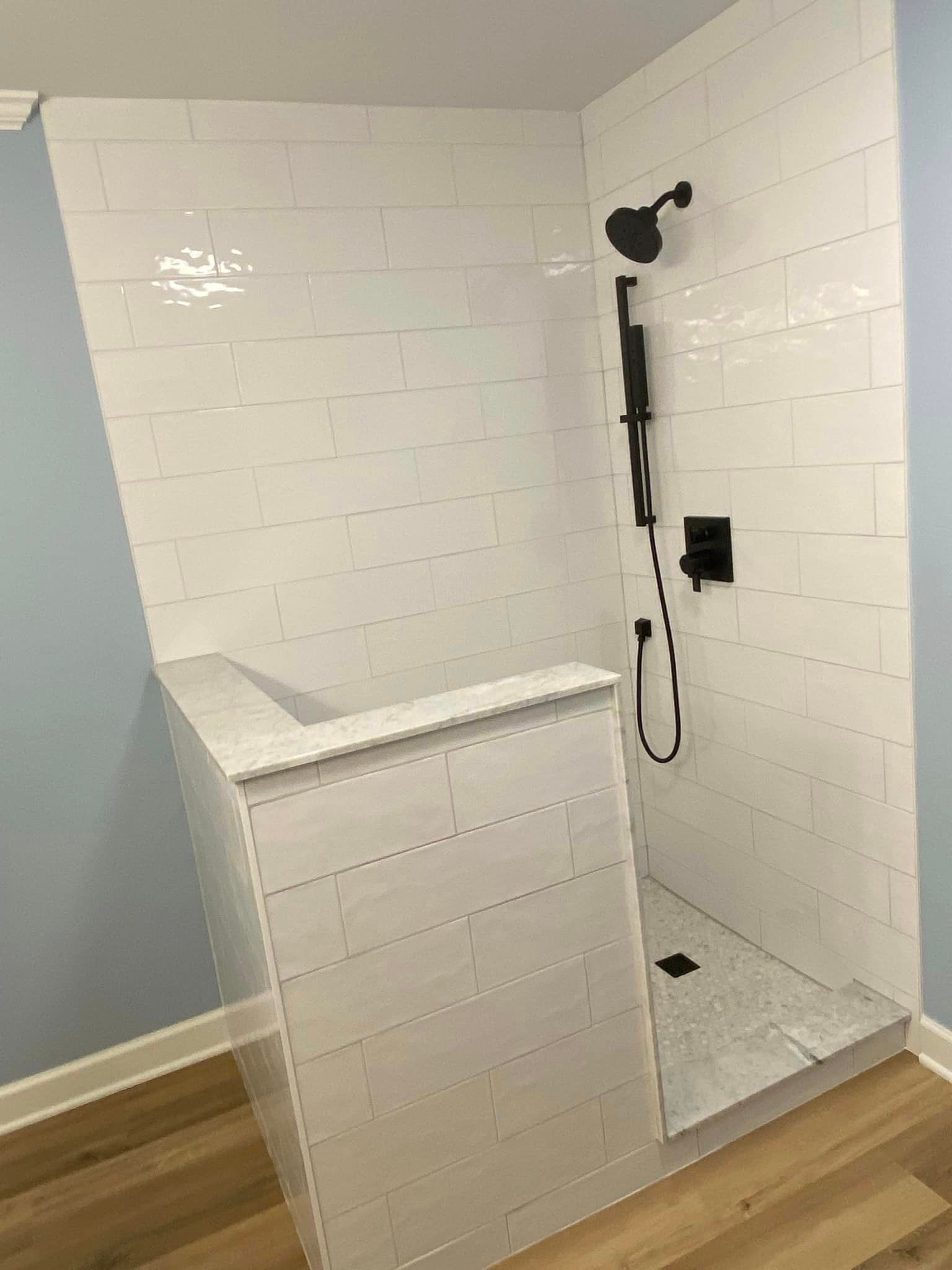 A & R Home Services remodel bathroom with a walk in shower and a black shower head.