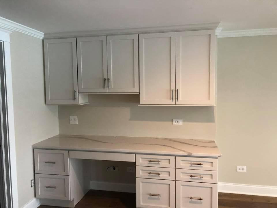 A & R Home Services remodel kitchen with white cabinets and a desk with drawers.