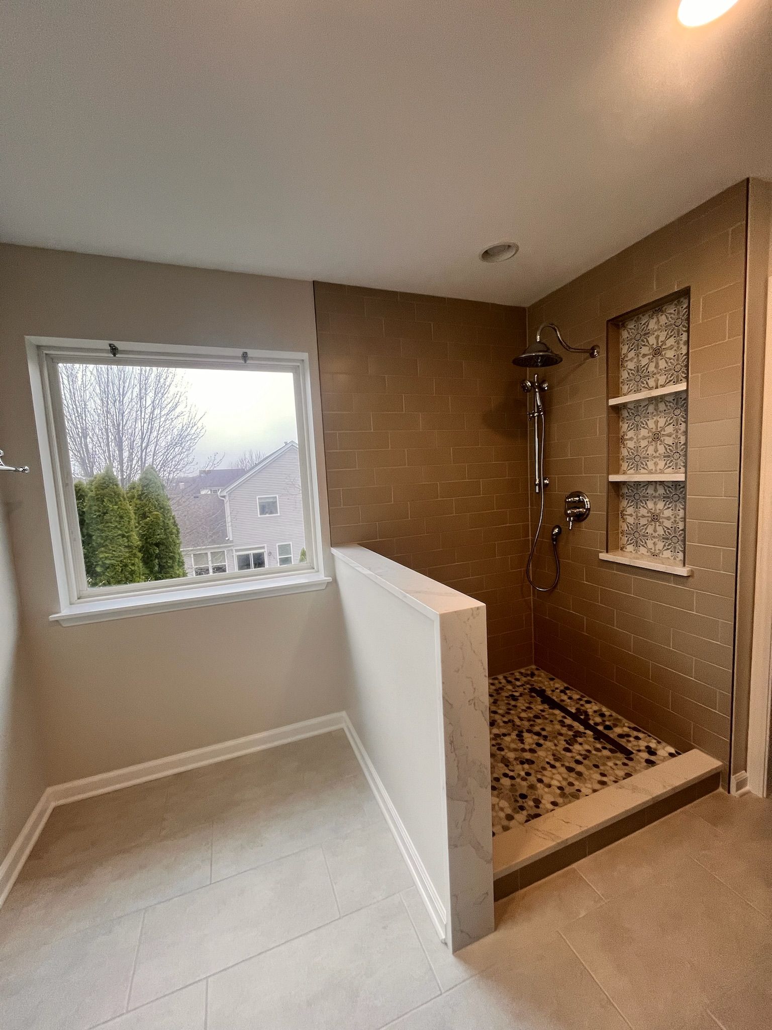 A & R Home Services remodel  bathroom with a walk in shower and a window.