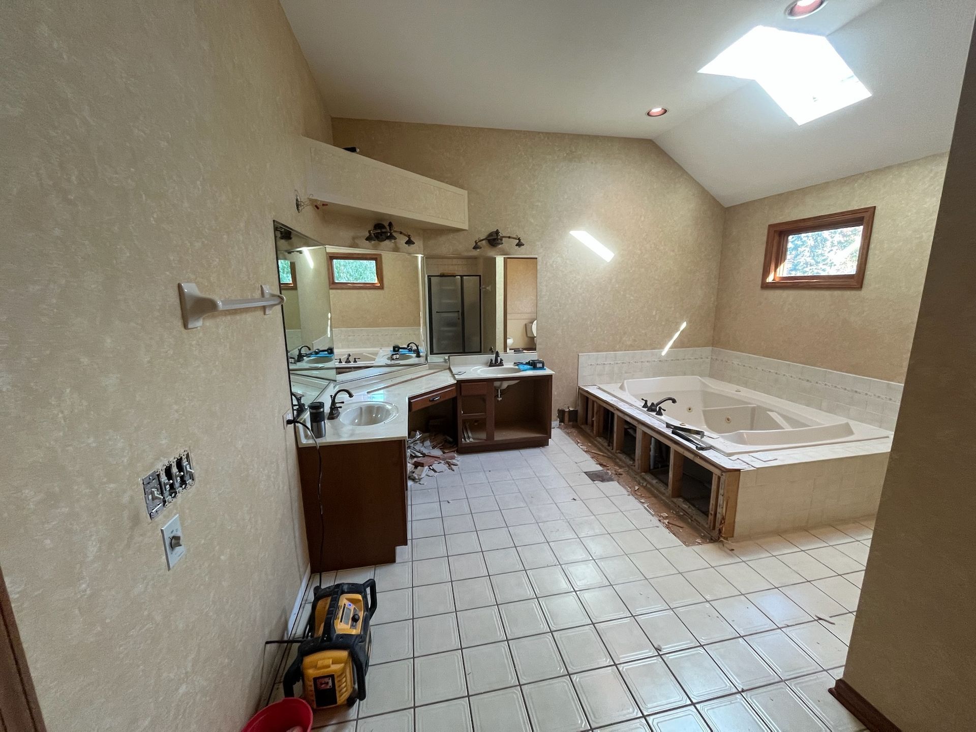 A & R Home Services remodel bathroom with two sinks , a tub and a skylight.