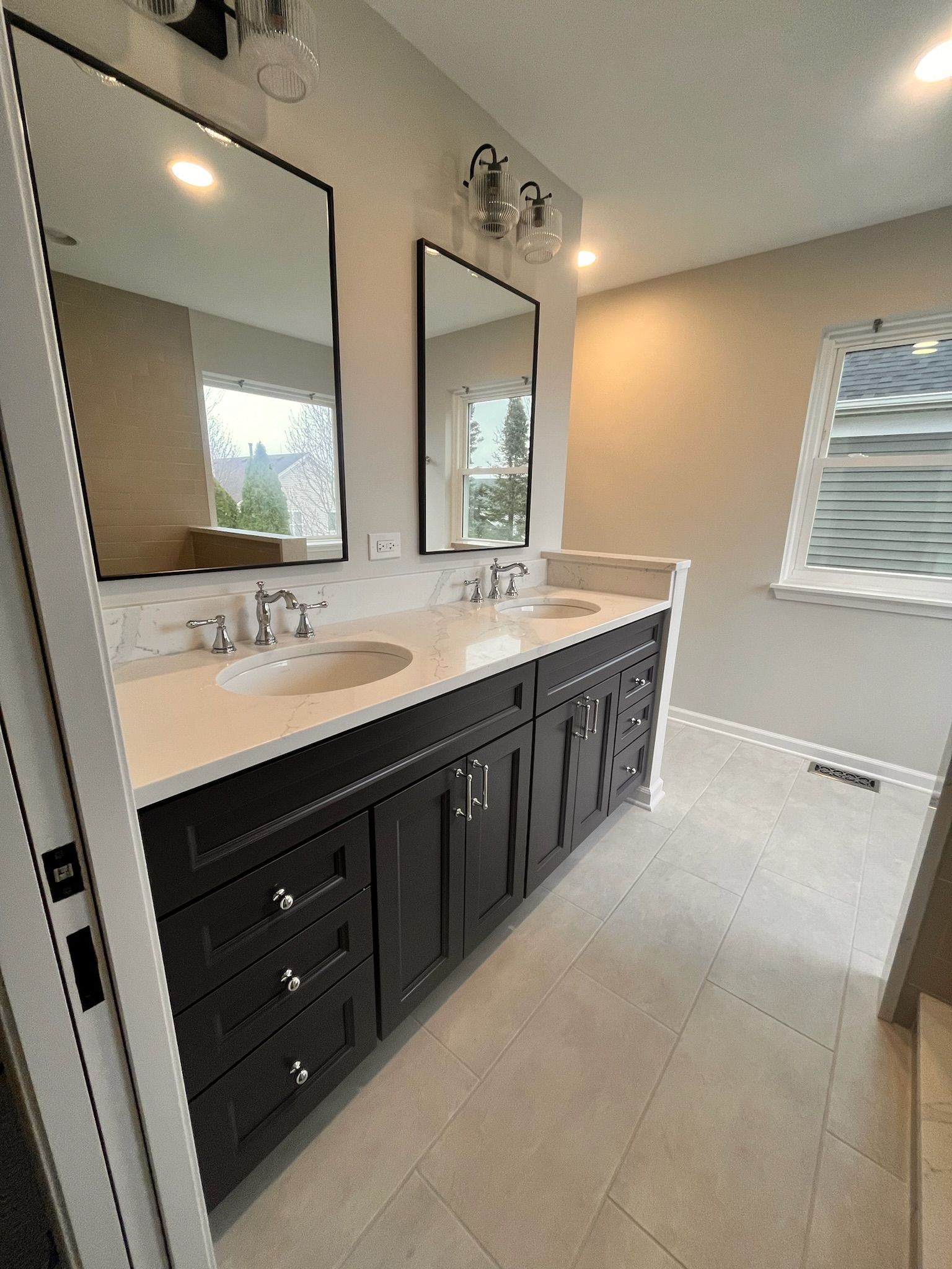 A & R Home Services remodel  bathroom with two sinks , two mirrors and a window.