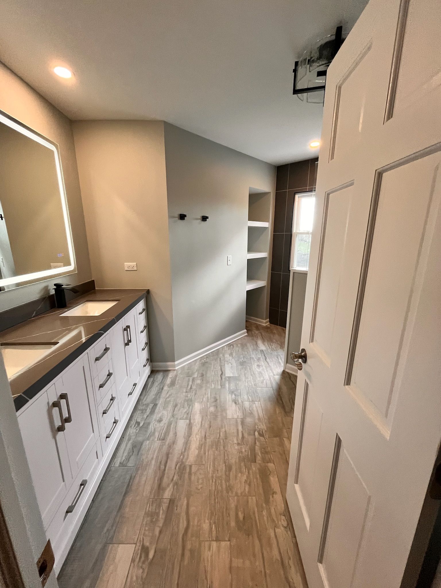 A & R Home Services remodel bathroom with two sinks , a mirror and a door.