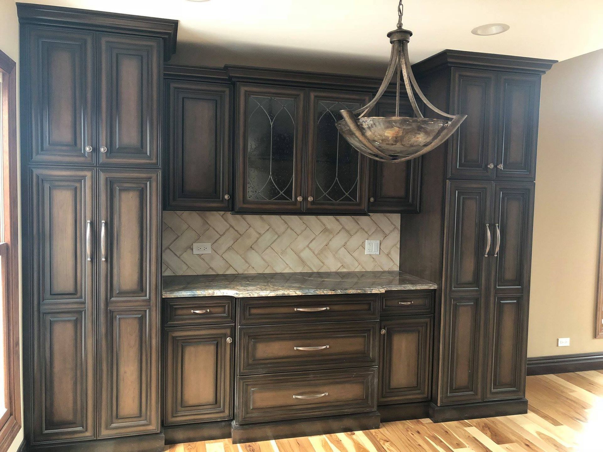 A & R Home Services  kitchen with a lot of cabinets and a chandelier hanging from the ceiling.