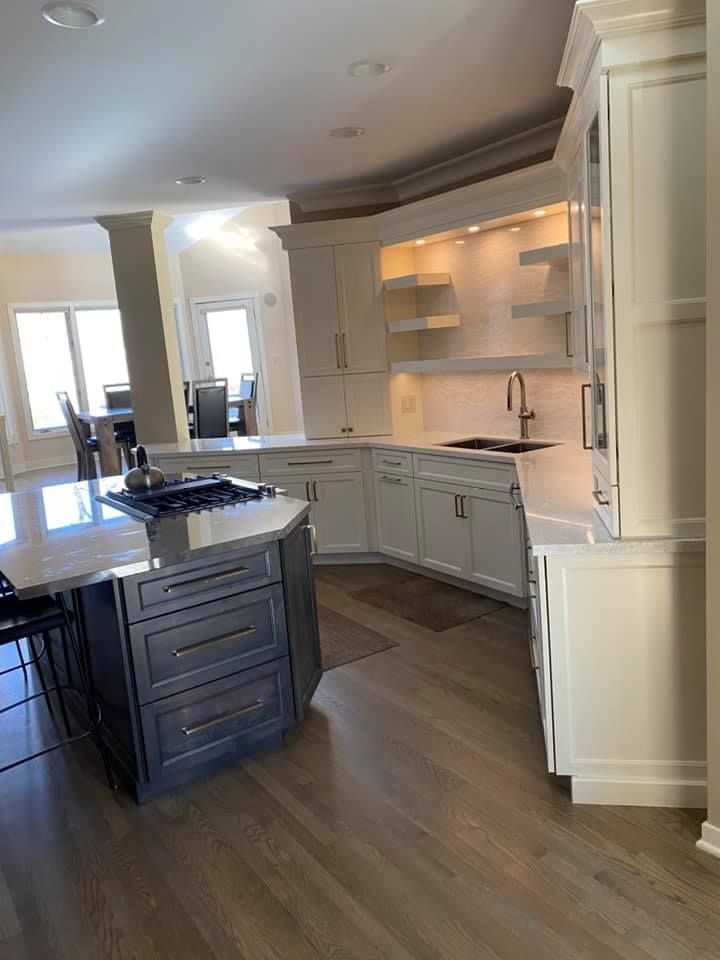 A & R Home Services  kitchen with white cabinets , granite counter tops , and a large island.