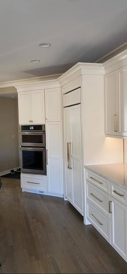 A & R Home Services kitchen with white cabinets and stainless steel appliances.