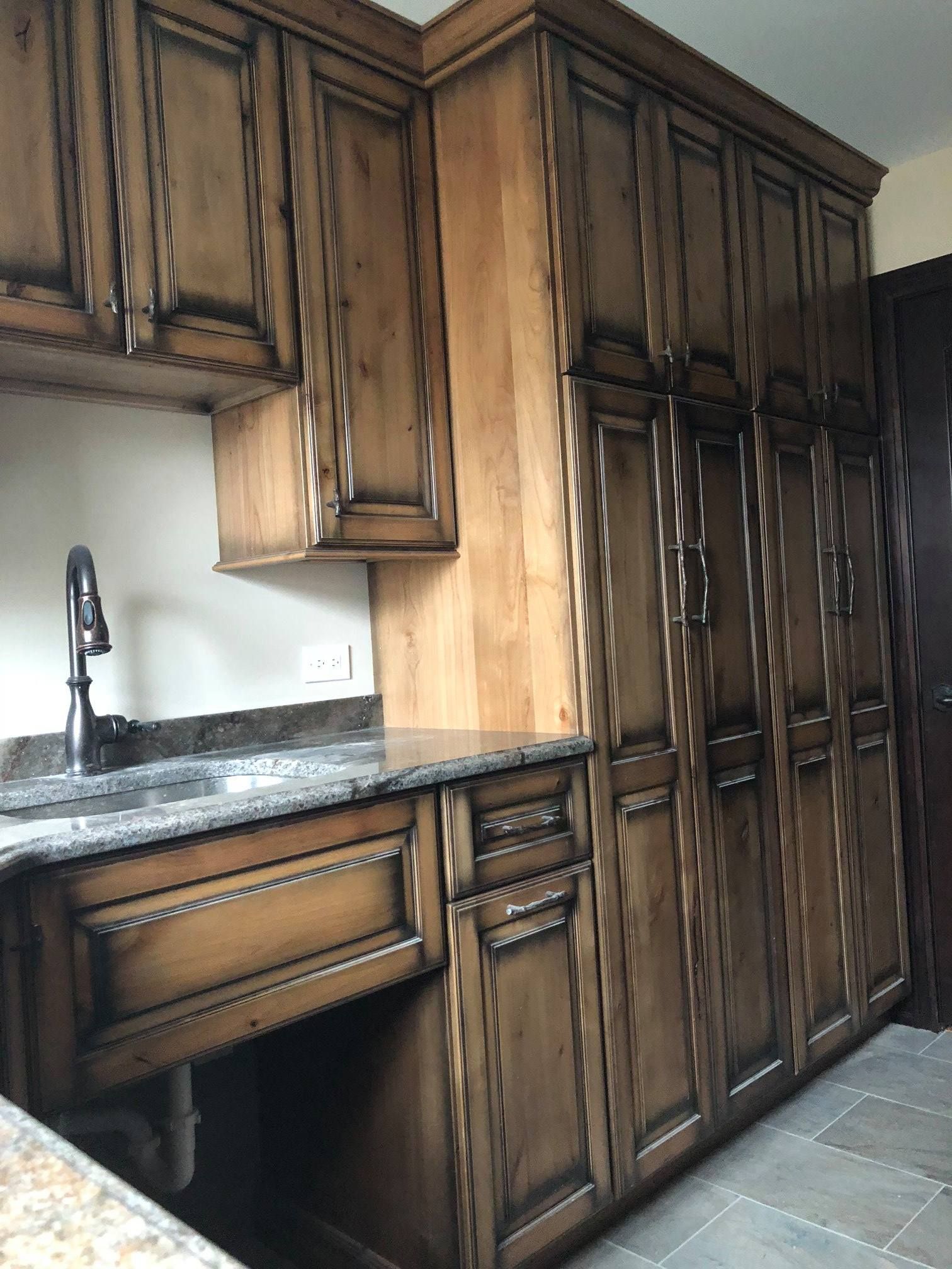 A & R Home Services remodel kitchen with wooden cabinets , granite counter tops , and a sink.