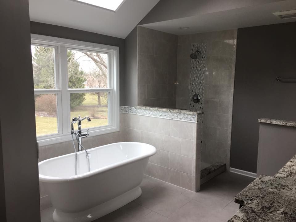 A bathroom with a bathtub and a walk in shower.