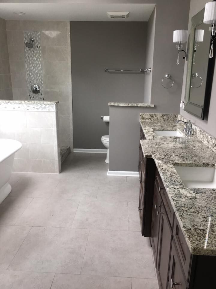 A & R Home Services remodel bathroom with two sinks , a toilet , and a walk in shower.