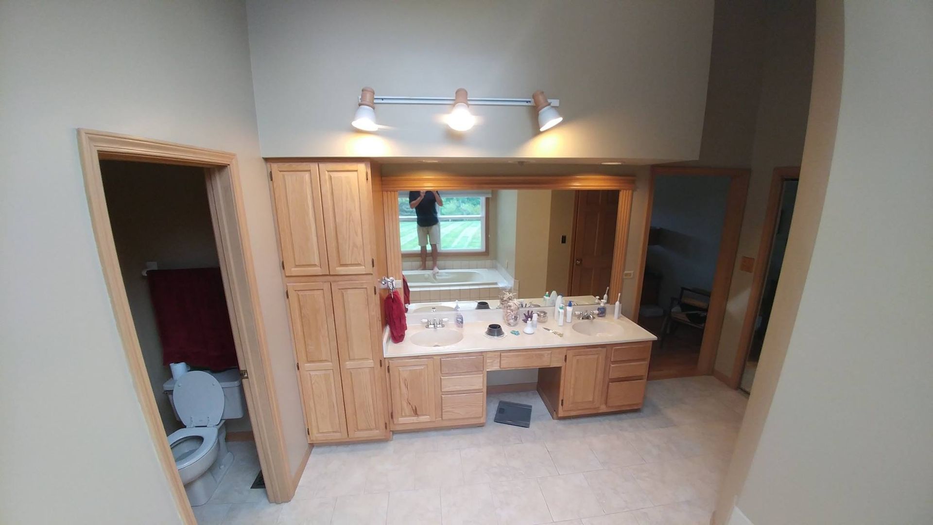 A & R Home Services remodel  bathroom with two sinks , a toilet , and a large mirror.