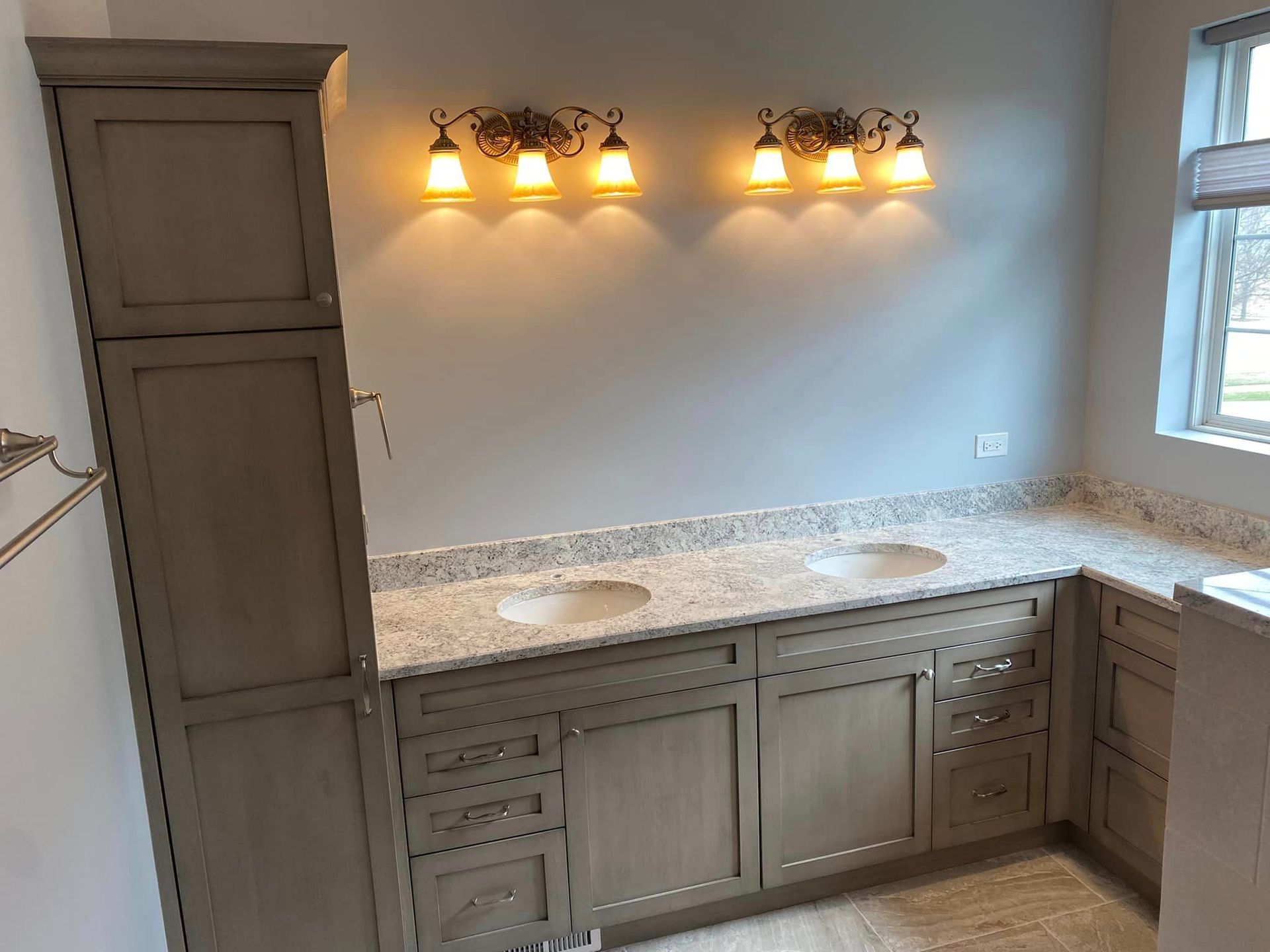 A & R Home Services remodel  bathroom with two sinks , a cabinet , and a window.