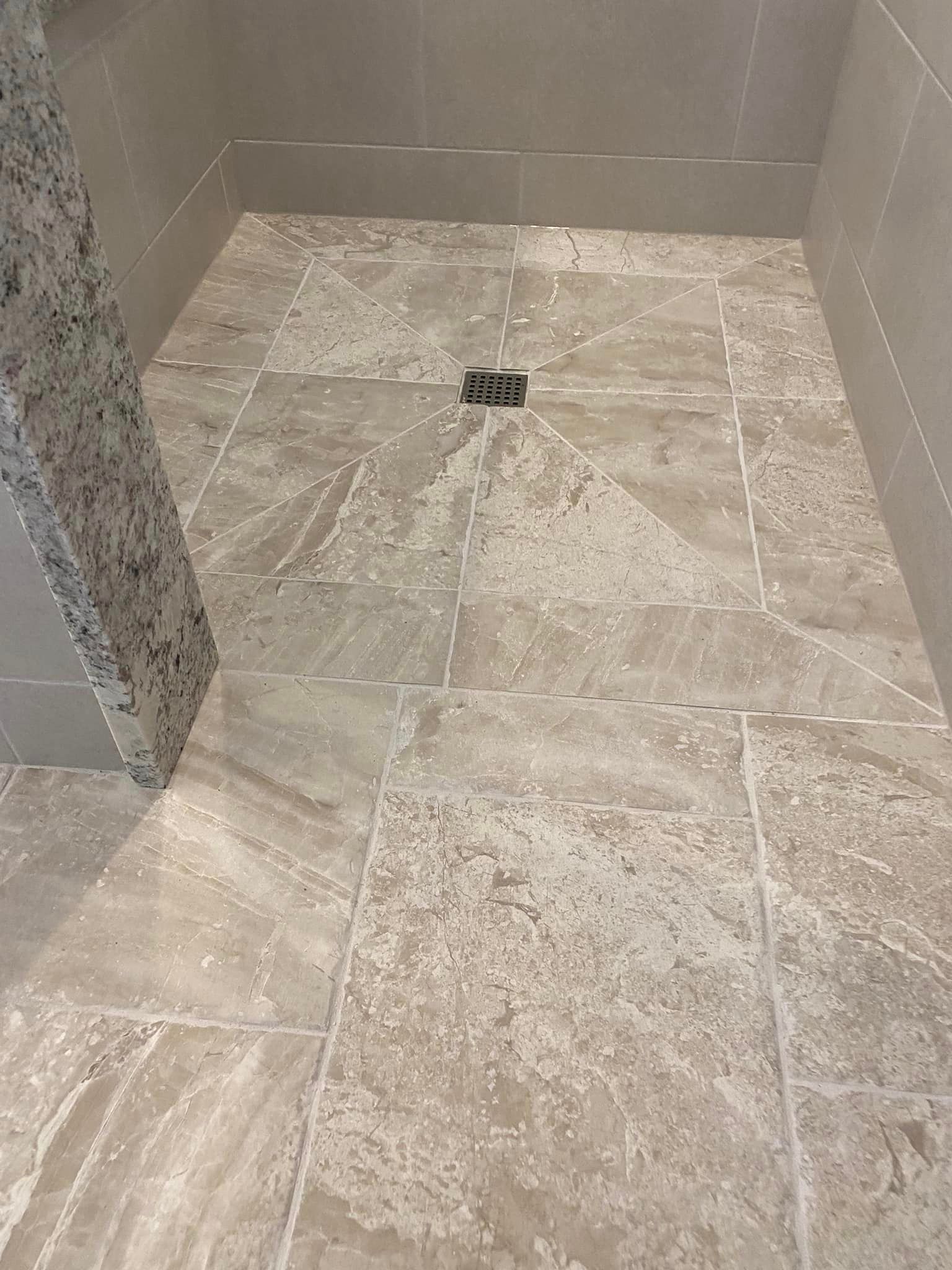 A & R Home Services remodel tiled floor in a bathroom with a drain.