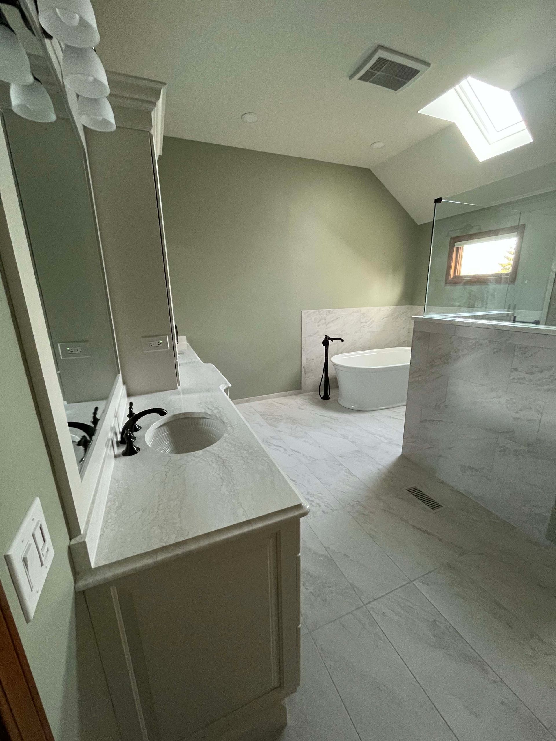 A & R Home Services remodel bathroom with two sinks , a tub and a skylight.