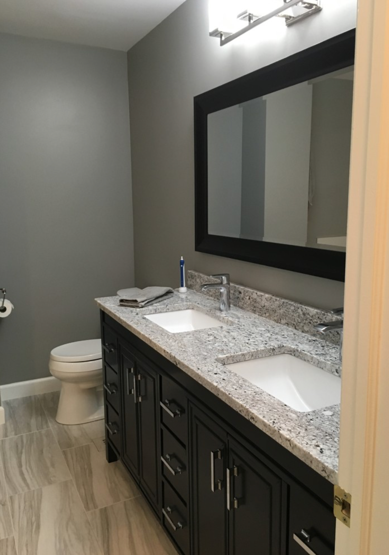 A & R Home Services remodel  bathroom with two sinks , a toilet and a mirror