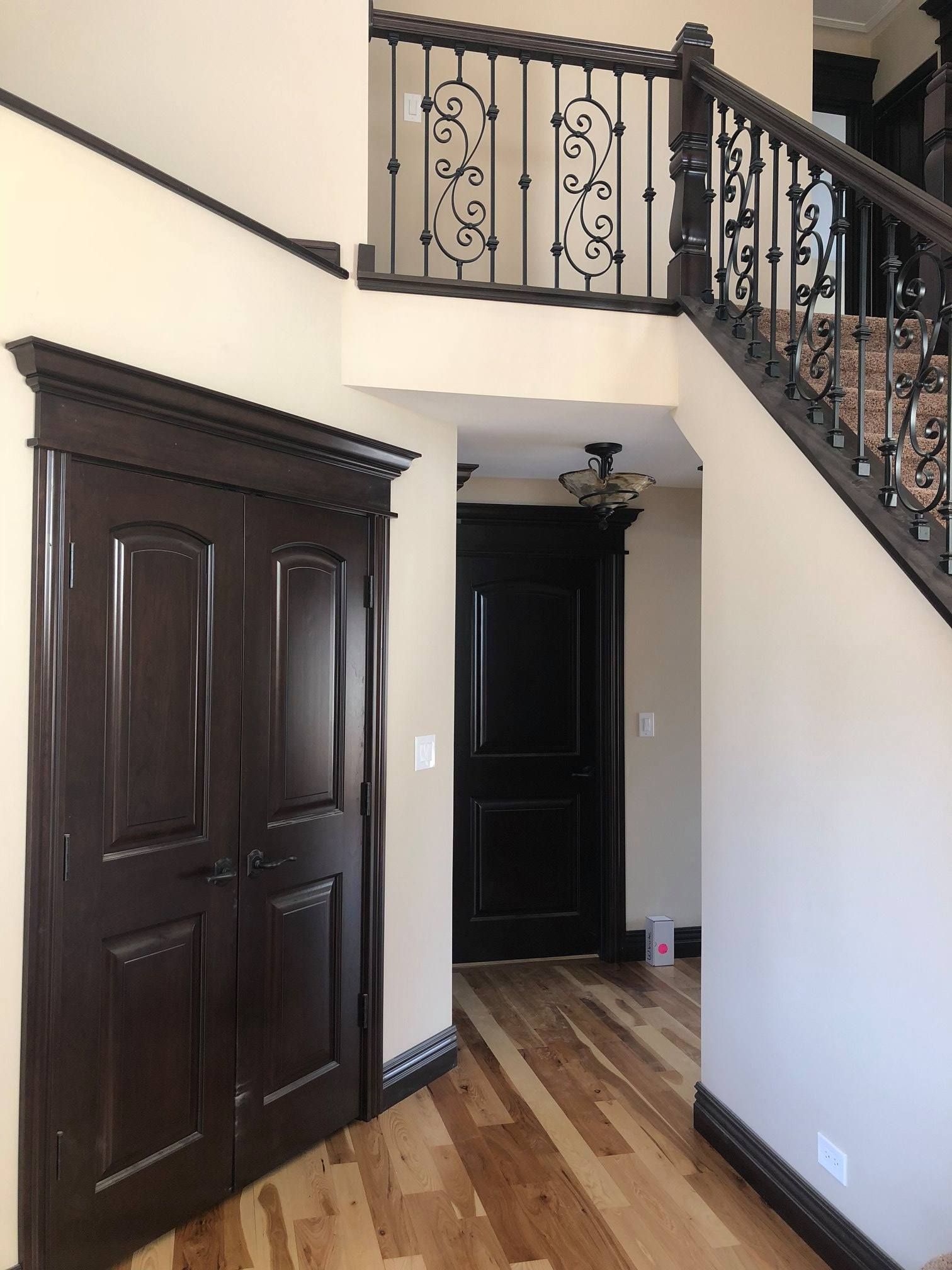 A & R Home Services remodel hallway with stairs and a wrought iron railing