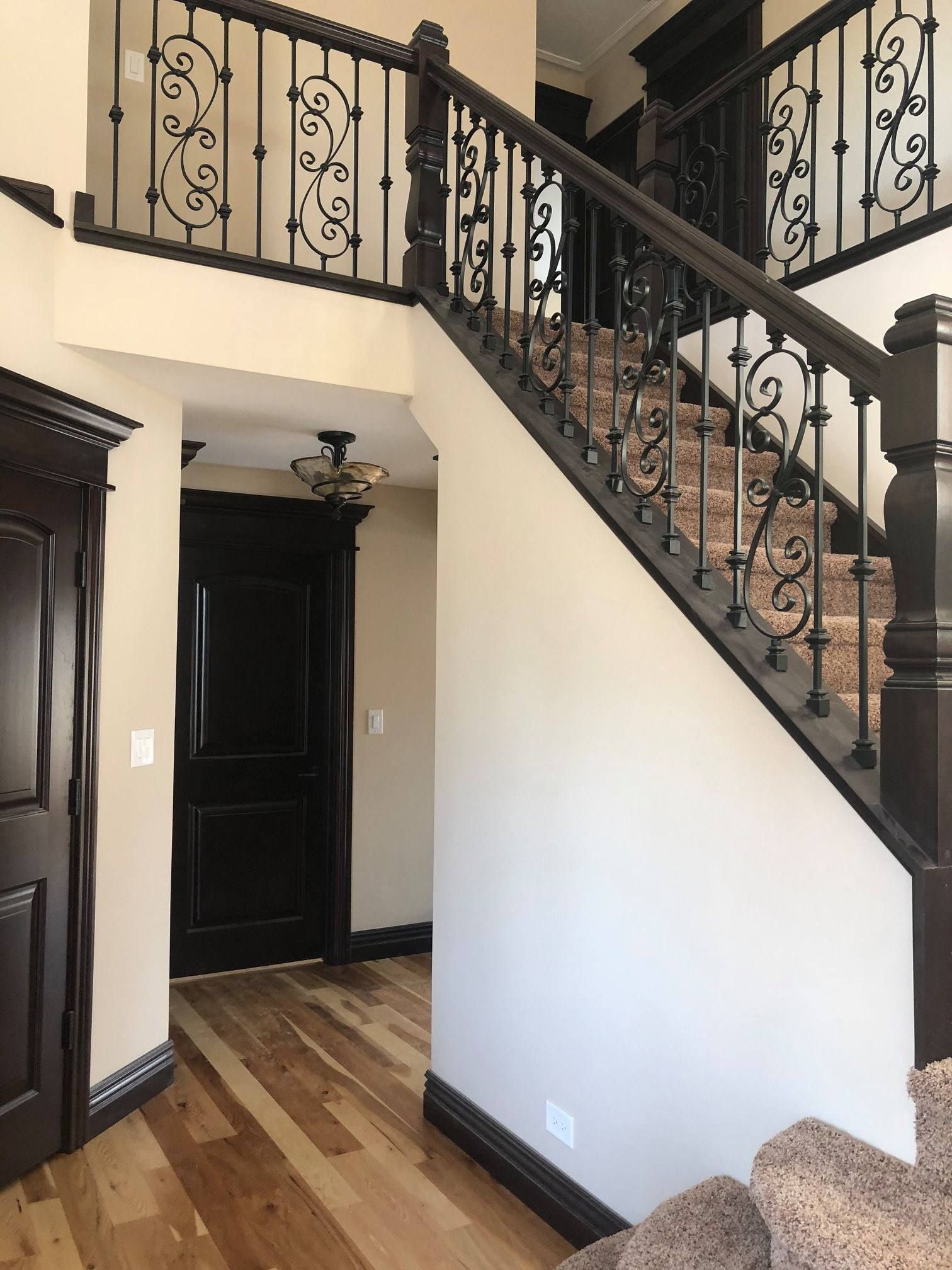 A & R Home Services remodel staircase in a house with a wrought iron railing