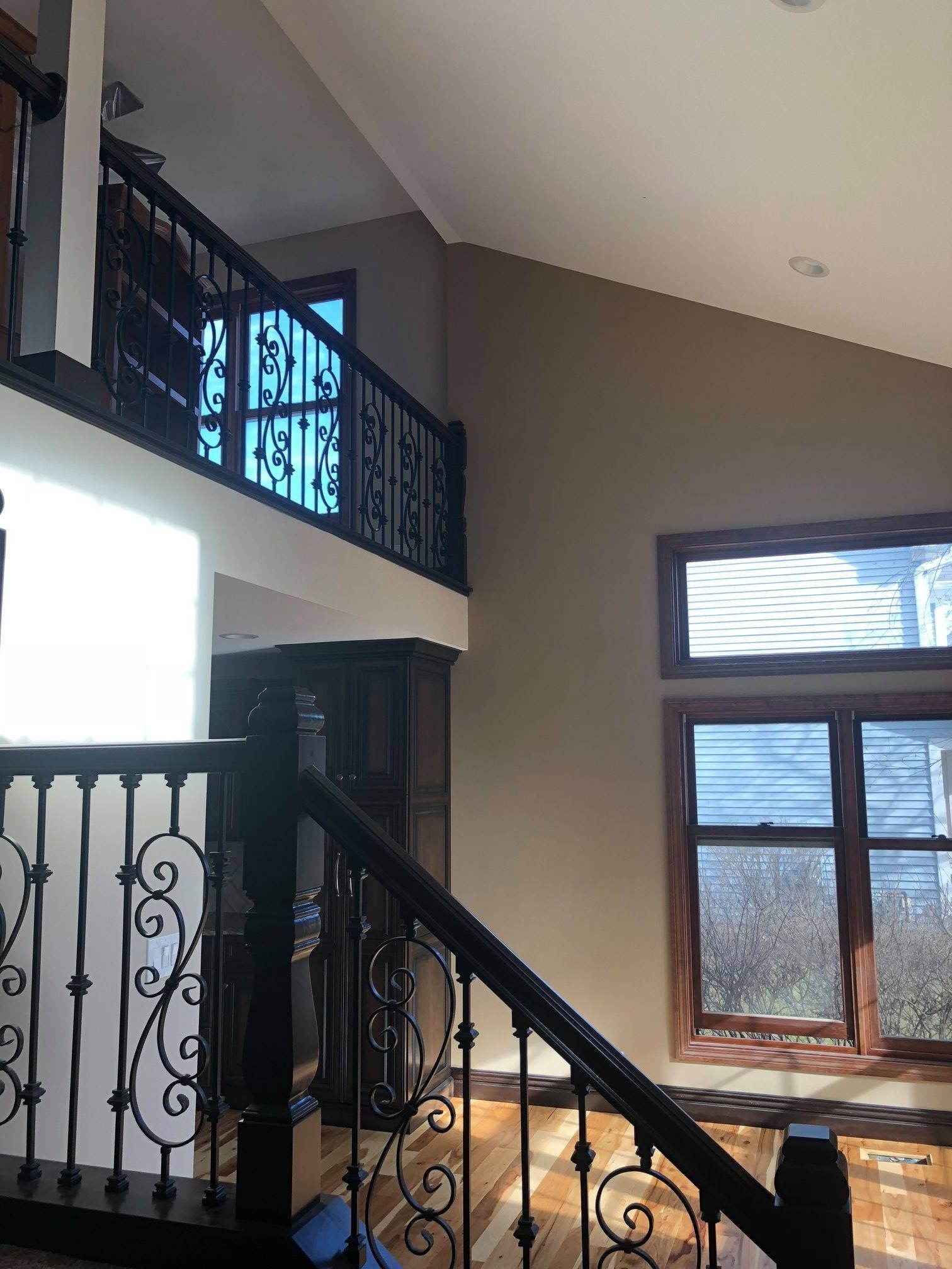 A & R Home Services remodel staircase with a wrought iron railing leading up to the second floor