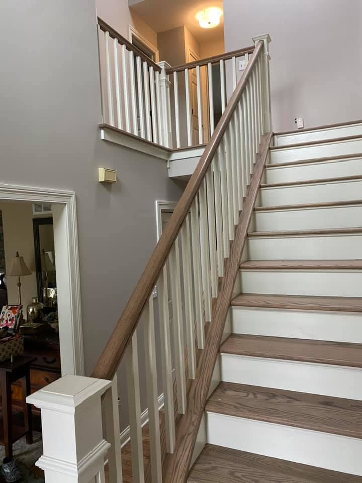 A & R Home Services remodel wooden staircase with white steps and a wooden railing