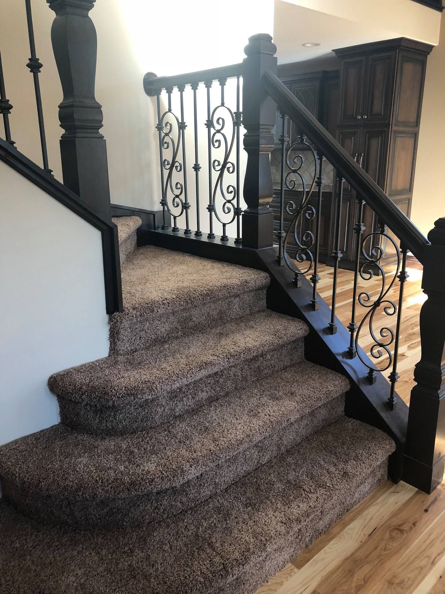 A & R Home Services remodel staircase with a carpeted staircase and a wrought iron railing.