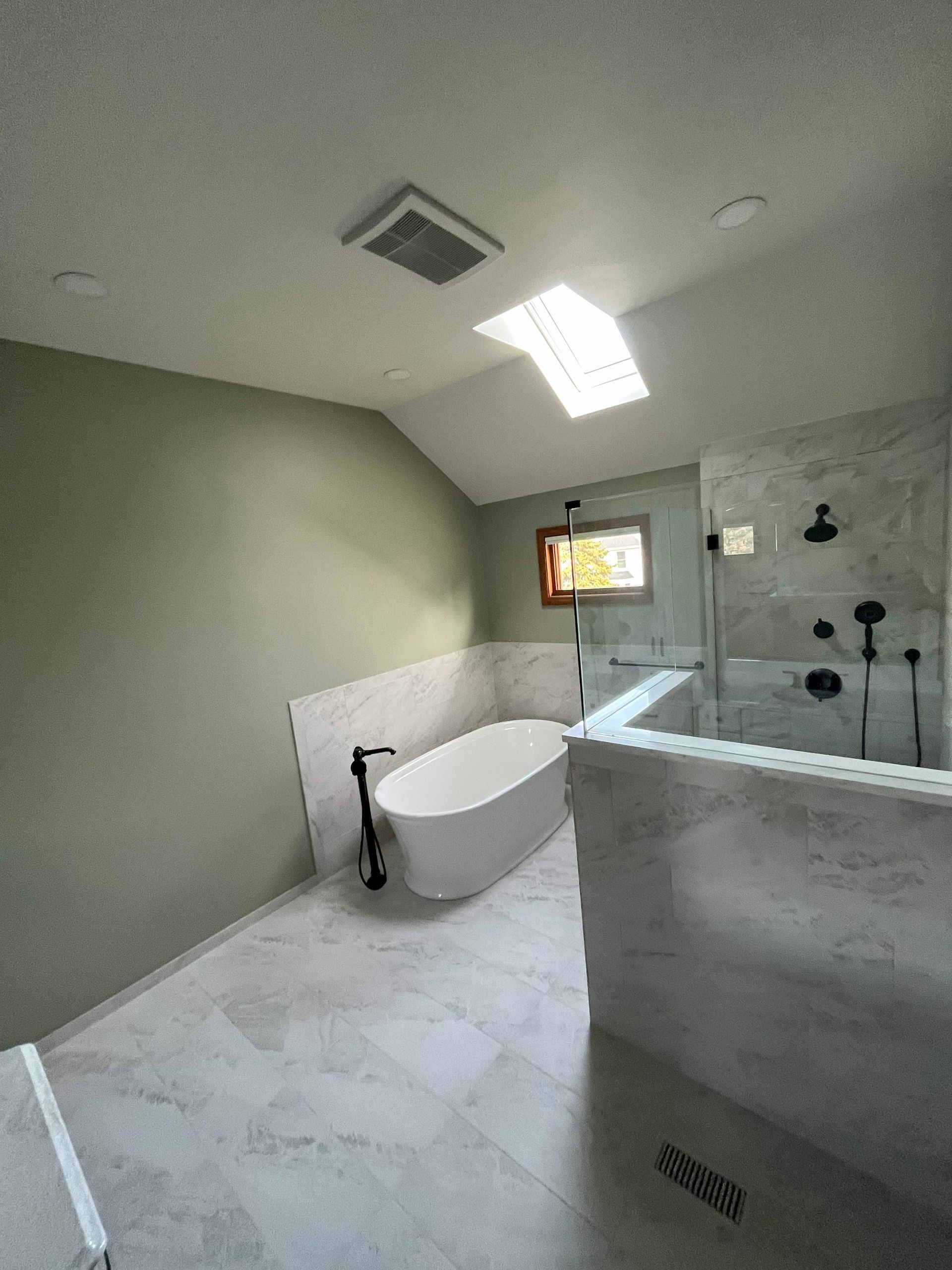 A & R Home Services remodel bathroom with a tub , shower , and skylight.