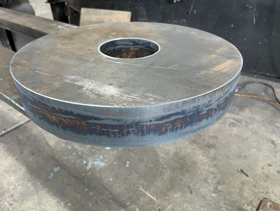 A piece of metal with a hole in the middle is sitting on a table.