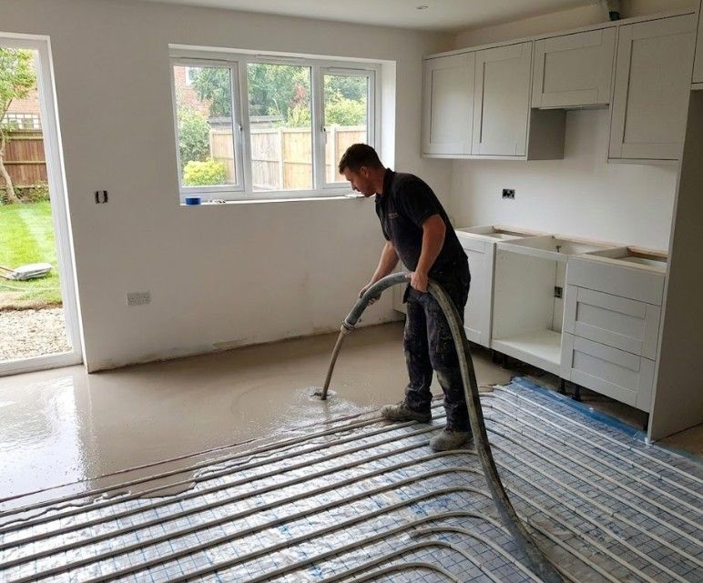 Flooring Nottingham applying liquid screed over underfloor heating pipes in a kitchen floor