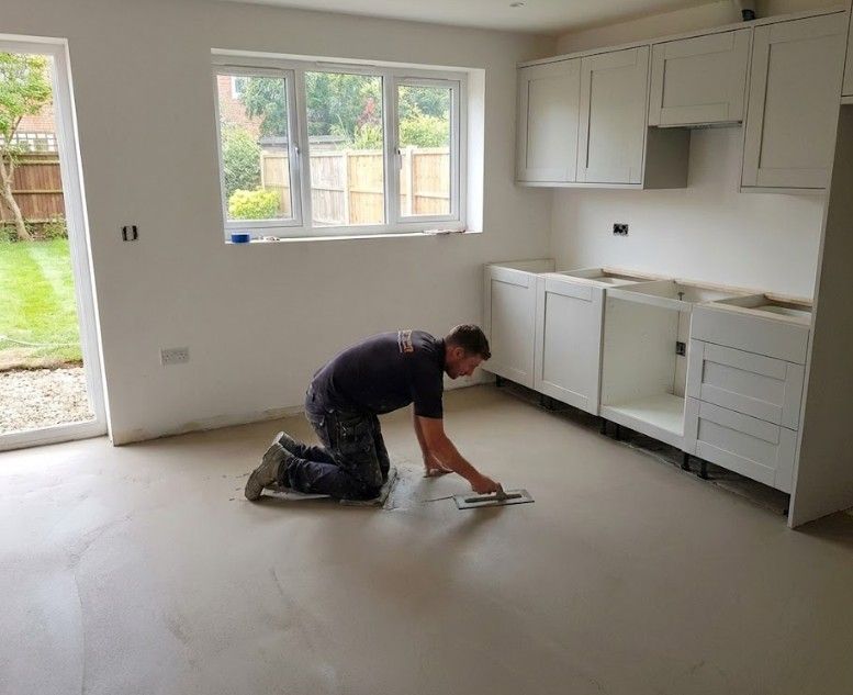 Flooring Nottingham trowelling flat liquid screed over underfloor heating pipes in a kitchen floor