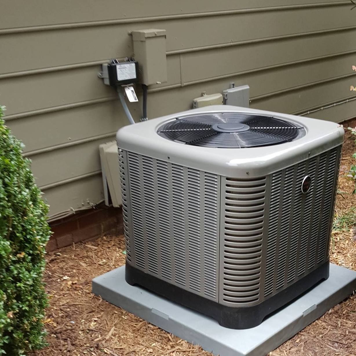a large air conditioner is sitting outside of a house