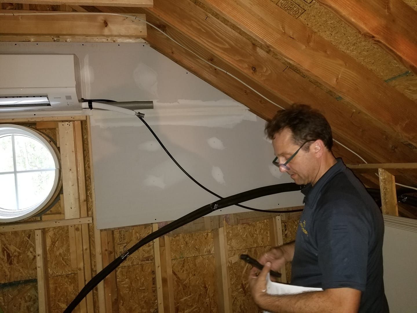 a man in a blue shirt is standing in an attic