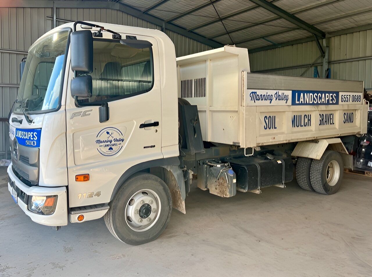 A White Dump Truck is Parked in a Warehouse — Manning Valley Landscapes in Gloucester, NSW