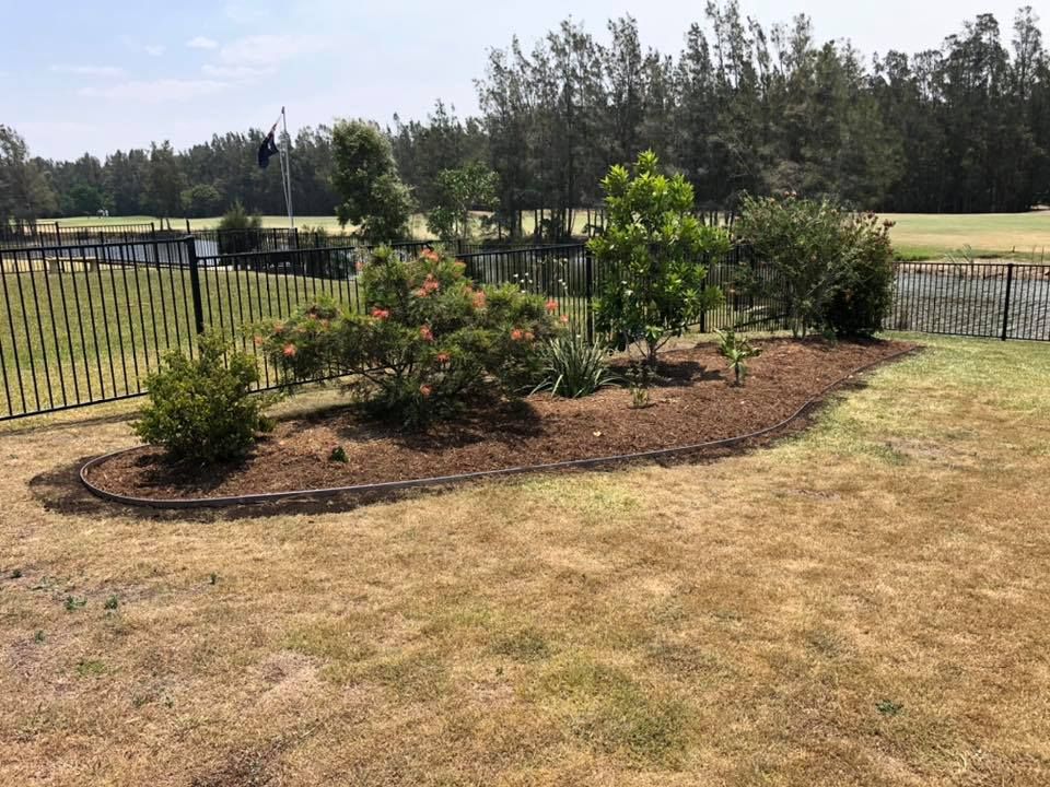 A Flower Bed With Various Shrubs and Mulch, Bordered — Manning Valley Landscapes in Forster, NSW