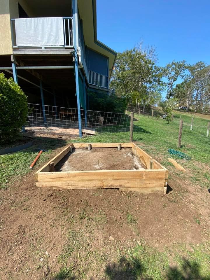 A Wooden Raised Garden Bed Sits on a Sloped Yard — Manning Valley Landscapes in Taree, NSW
