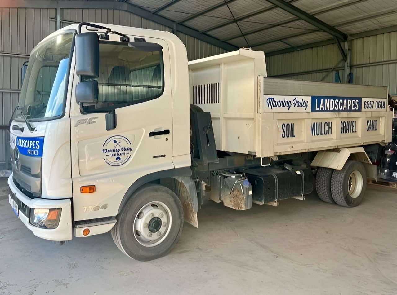 A White Dump Truck is Parked in Front of a Building — Manning Valley Landscapes in Wingham, NSW