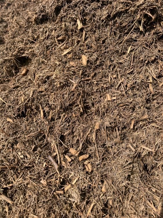 A Pile of Brown Mulch is Sitting on the Ground — Manning Valley Landscapes in Old Bar, NSW
