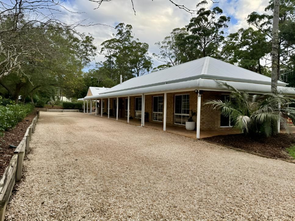 A Man is Using a Drill on a Metal Roof — Manning Valley Landscapes in Wingham, NSW