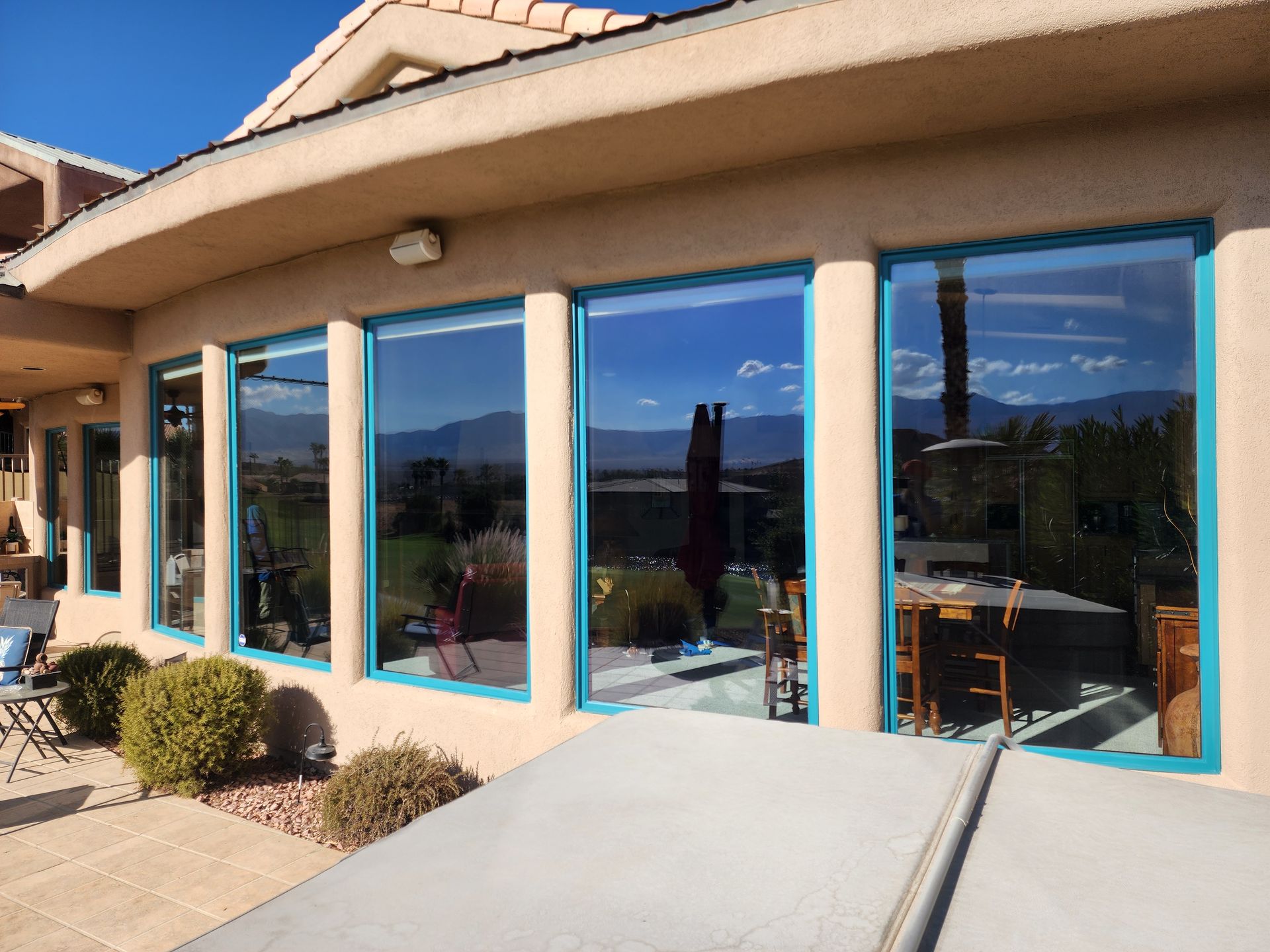 A house with a lot of windows and a hot tub