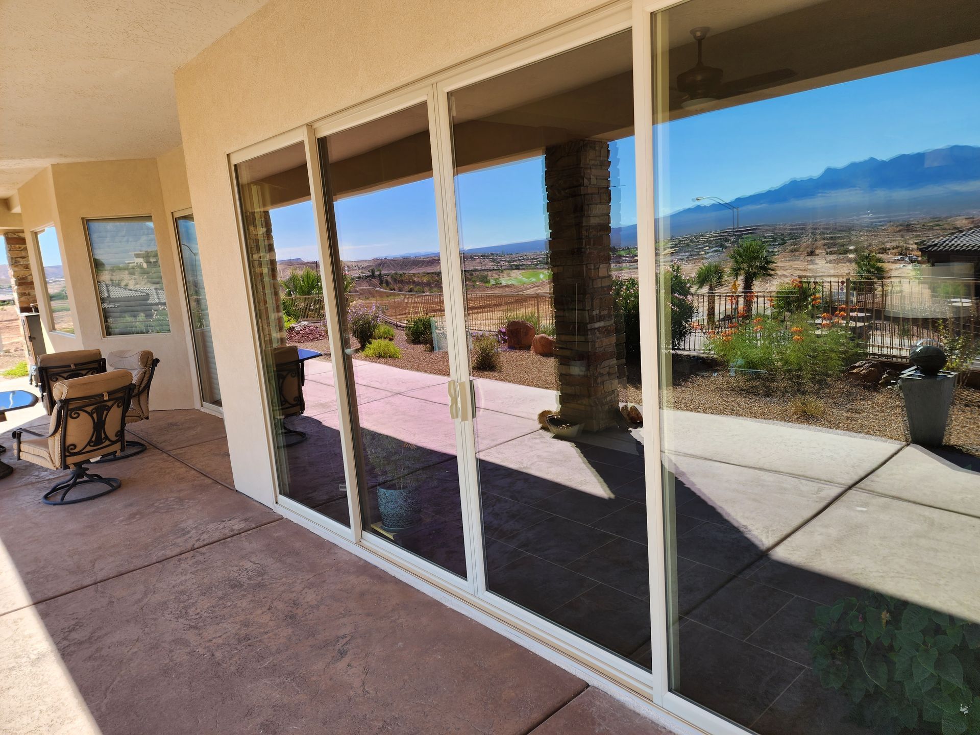 A large sliding glass door with a view of a patio and mountains.
