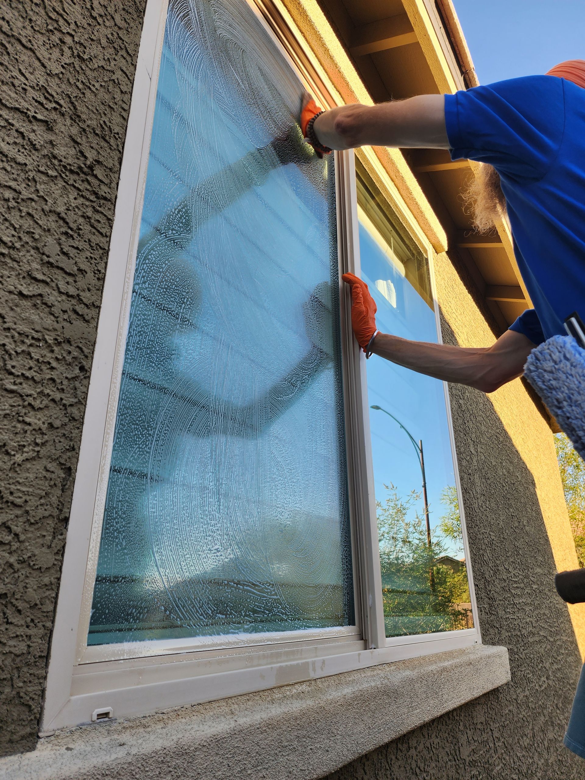 A man is cleaning a window with a squeegee.