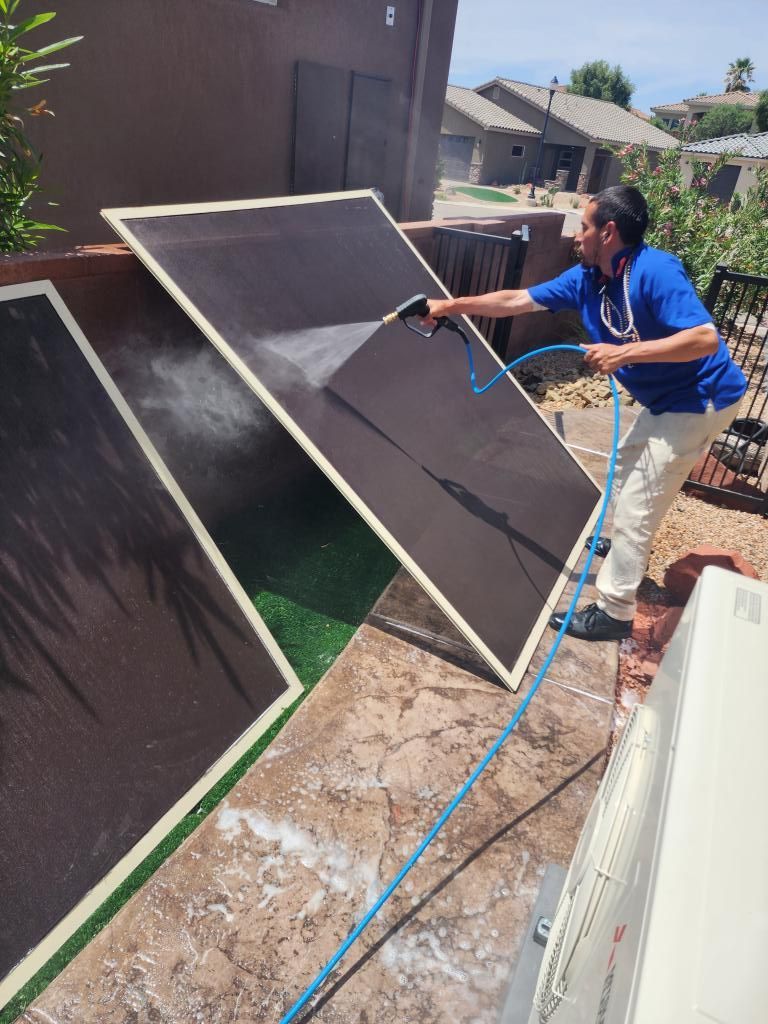 A man is cleaning a solar panel with a hose