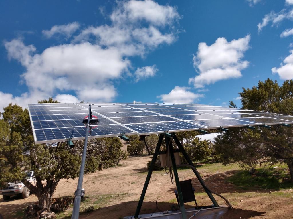 A large solar panel is sitting in the middle of a field.