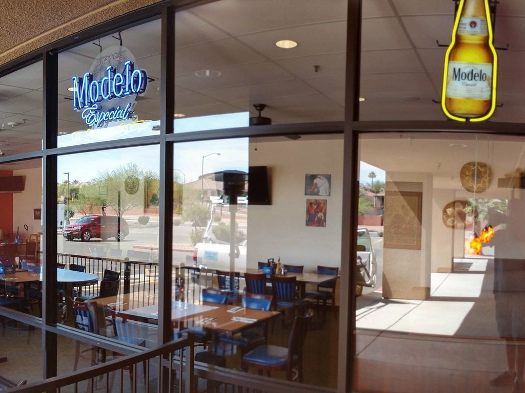 A restaurant with a neon sign that says modelo on it